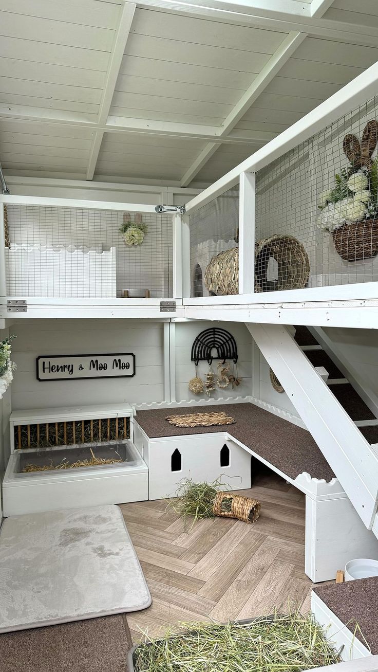 a white cat house with stairs leading up to the second floor