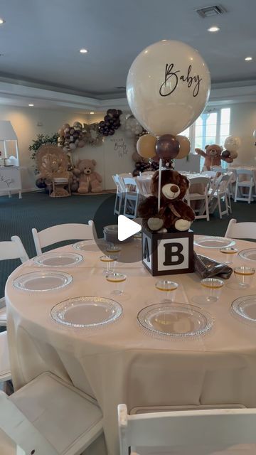 a teddy bear centerpiece on top of a table at a baby's first birthday party