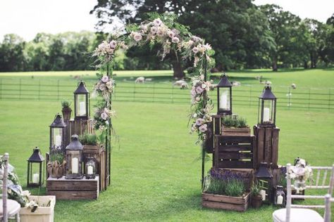 an outdoor ceremony setup with lanterns and flowers