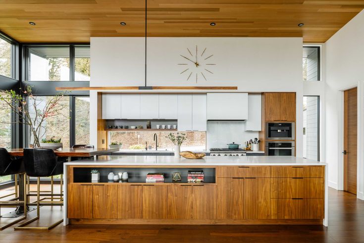 a kitchen with wooden floors and white walls, along with an island in the middle