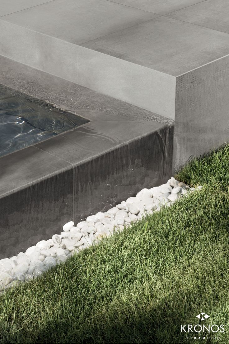 a fire hydrant sitting on top of a lush green field next to a swimming pool