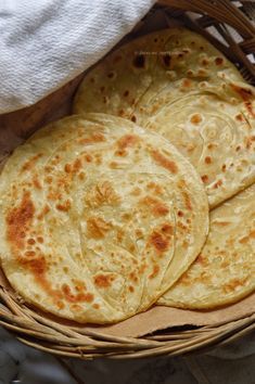 four flat breads in a basket on a table