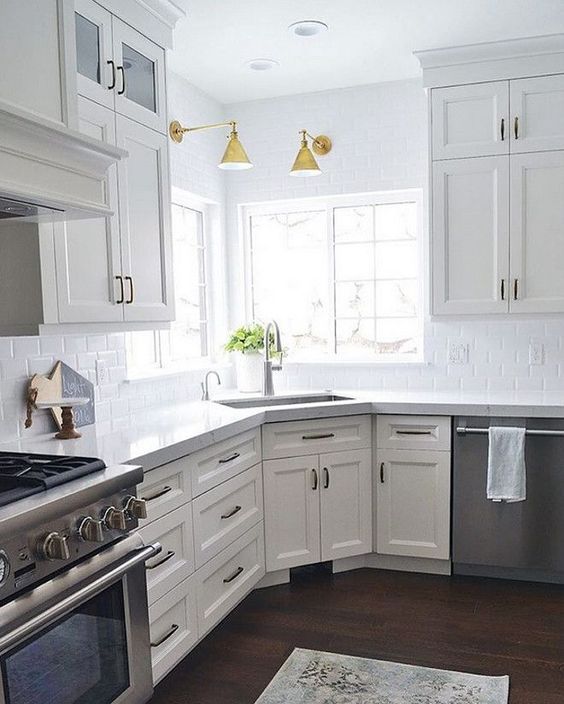 a kitchen with white cabinets and marble counter tops on instagramting from the app