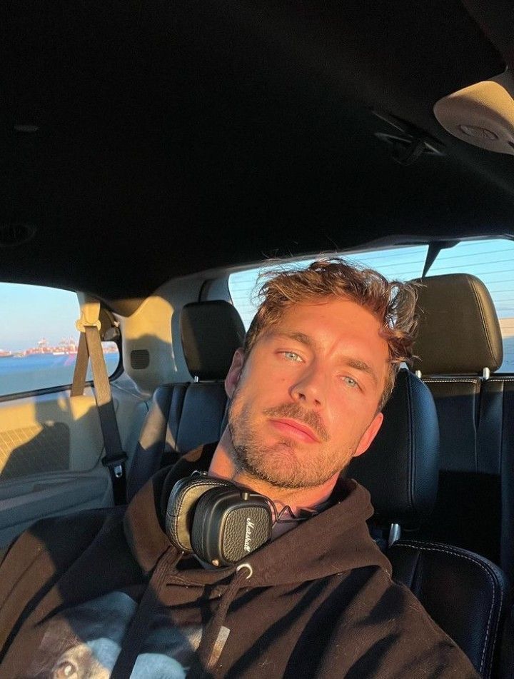 a man sitting in the back seat of a car with headphones on his ears