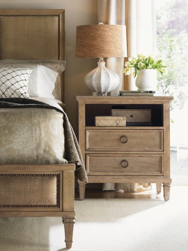 a bedroom scene with focus on the nightstand and bed