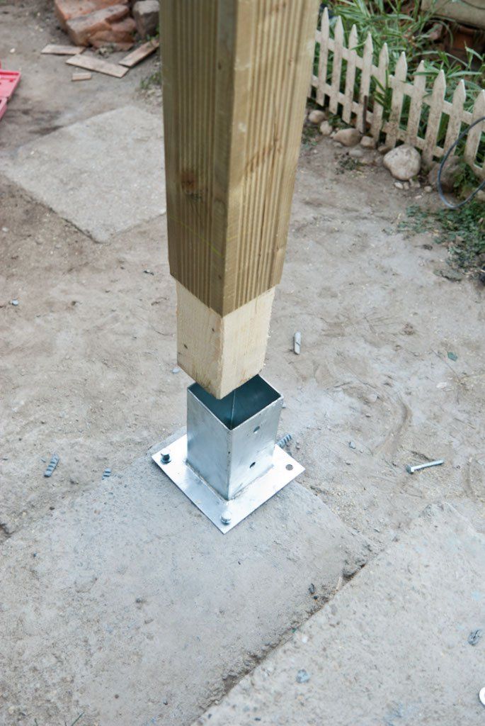 a wooden pole with a metal base on the ground