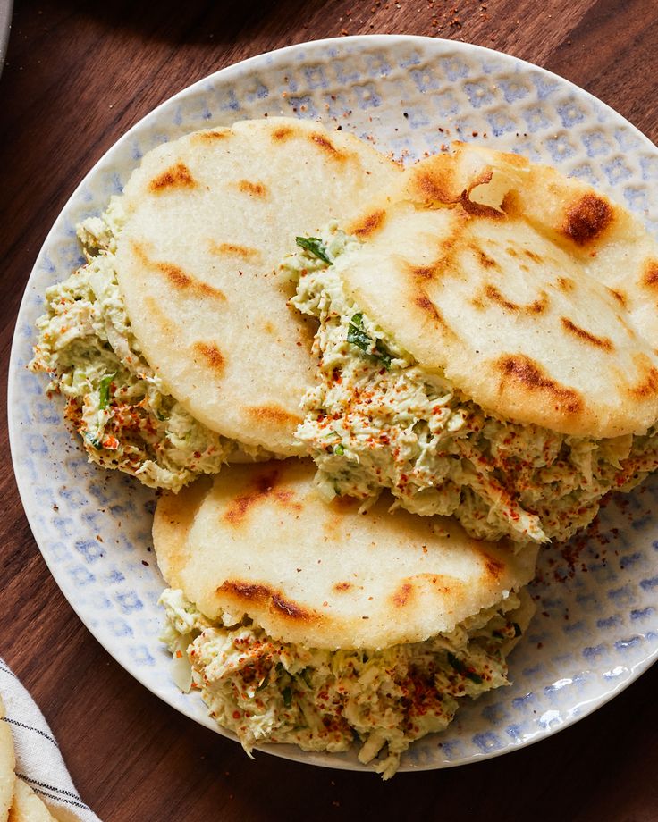 three flat breads on a plate with sauce and seasoning sprinkles