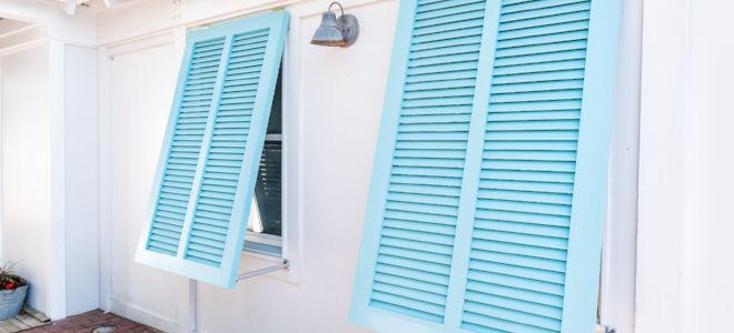 two blue shutters on the side of a white house