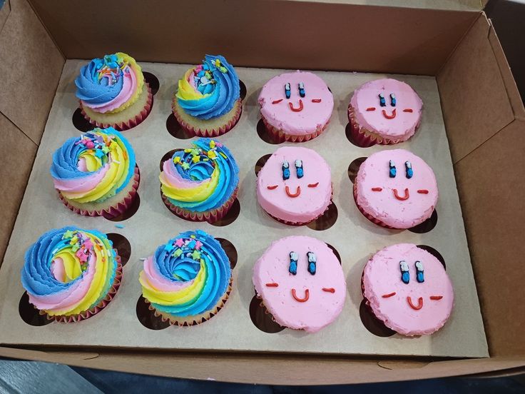 a box filled with lots of colorful cupcakes covered in frosted icing