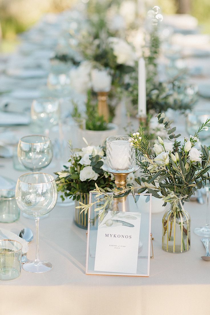 the table is set with candles, flowers and wine glasses for an elegant wedding reception