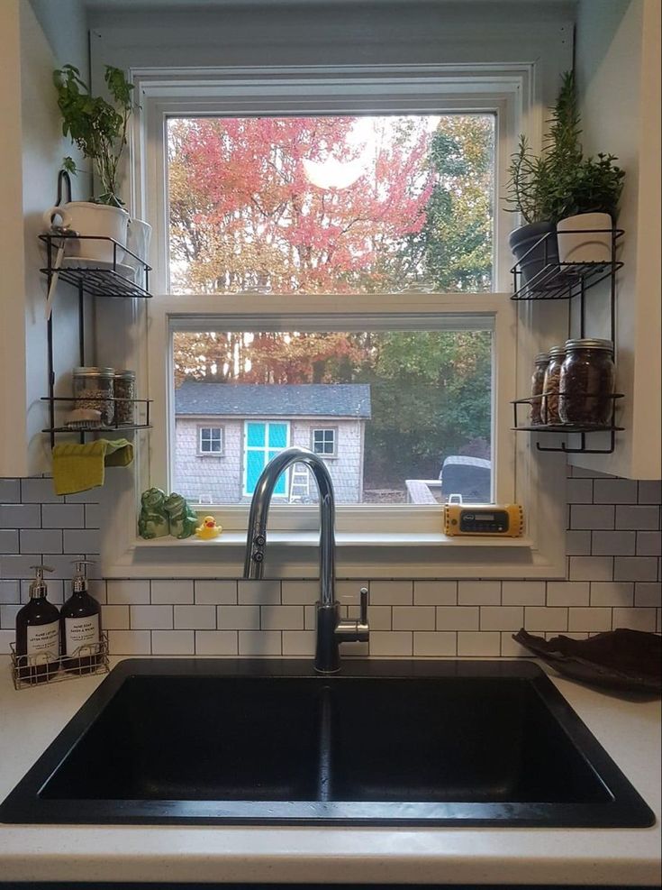 a kitchen sink sitting under a window next to a counter