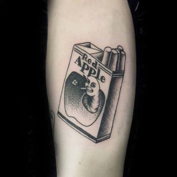 a black and white tattoo with an apple in a bag on the arm, reading real apple