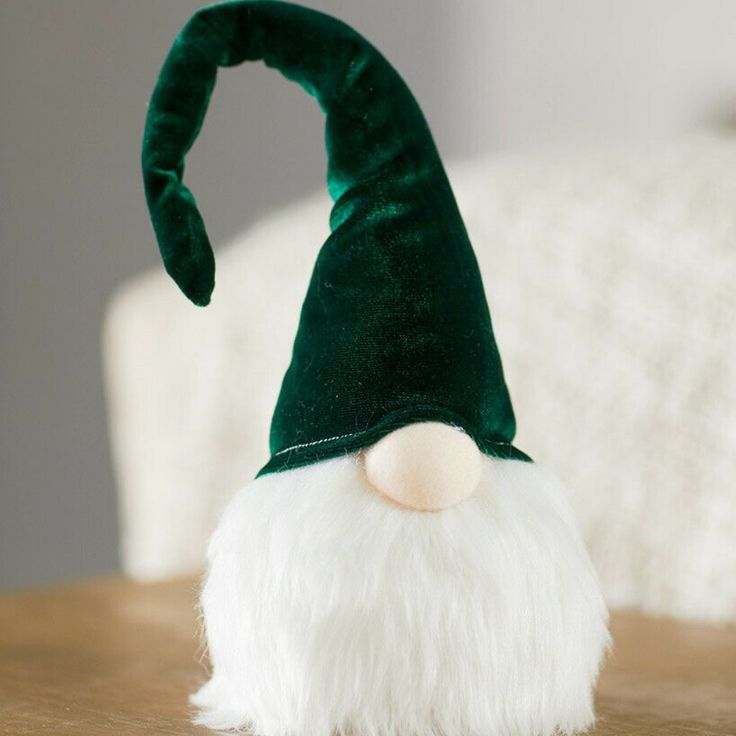 a green and white gnome hat sitting on top of a wooden table