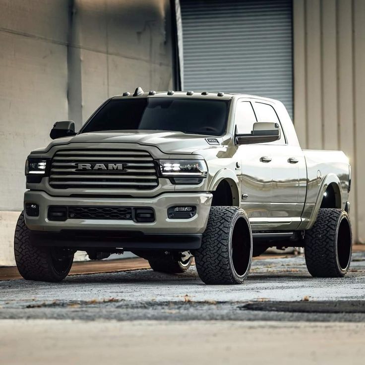 a silver ram truck parked in front of a building