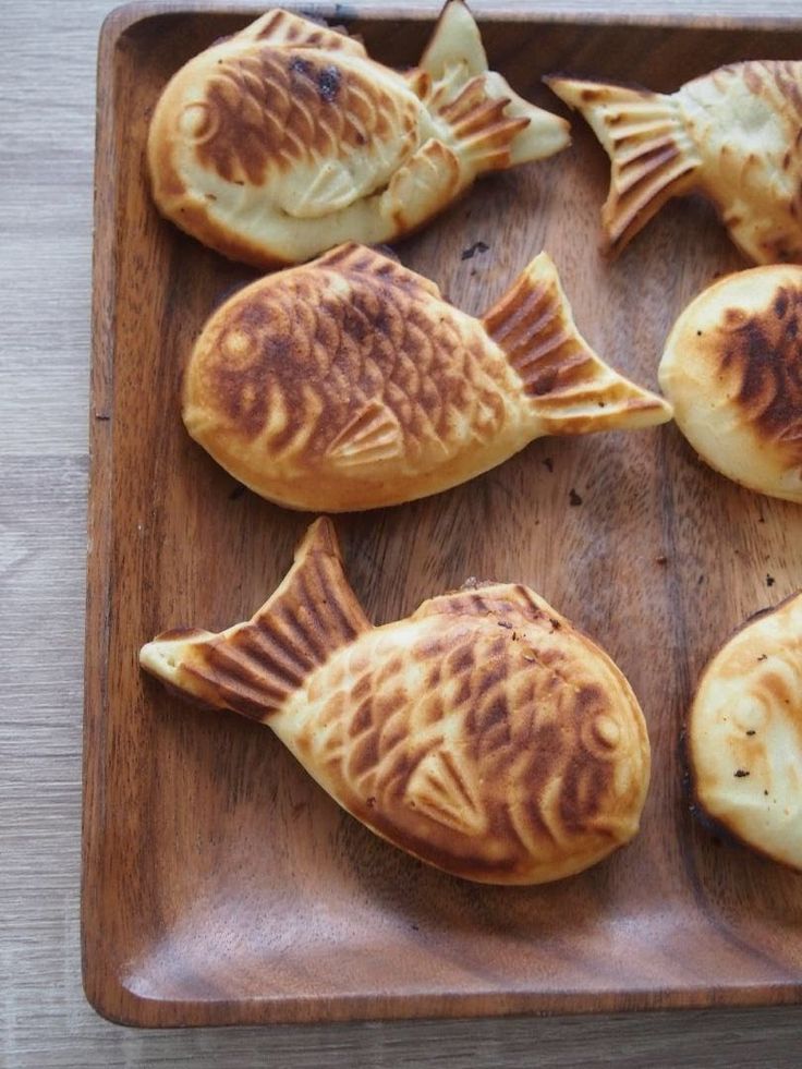 some kind of food that is on a wooden platter and ready to be eaten