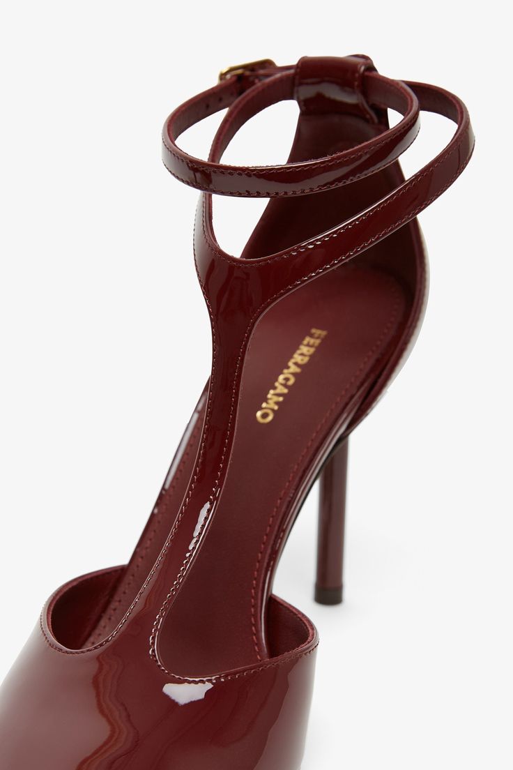 Dark red patent leather pumps from Ferragamo. The Lysandra pump is made of patent leather, have a rounded toe and a slender t-strap that wraps around the ankles, and sits on a 95 mm stiletto heel.Measurements: L30 x H13 x W9 cmMade in Italy Strap Pumps, Patent Leather Pumps, T Strap, Leather Pumps, Stiletto Heel, Dark Red, Stiletto Heels, Patent Leather, Pumps