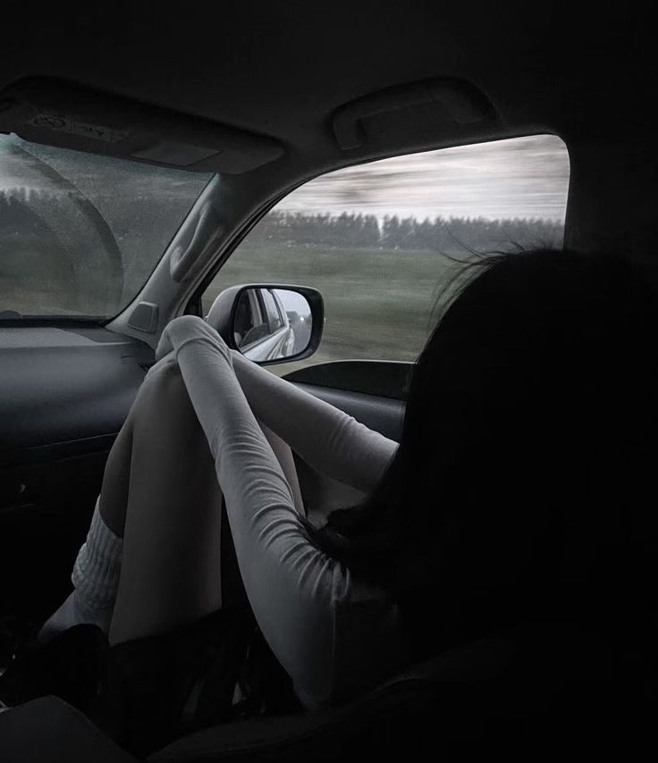 a woman sitting in the passenger seat of a car