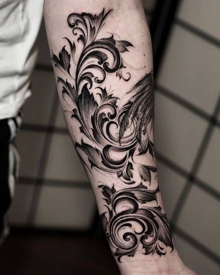 a black and white photo of a tattoo on the arm, with an intricate design