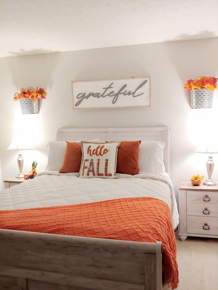 a bed with orange and white pillows in a bedroom