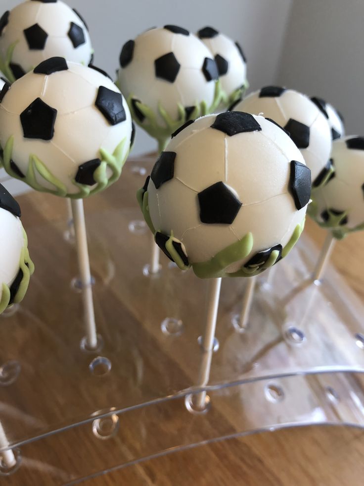 there are many cake pops with soccer balls on them