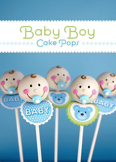 baby shower cake pops with blue and green decorations on sticks in front of a blue background