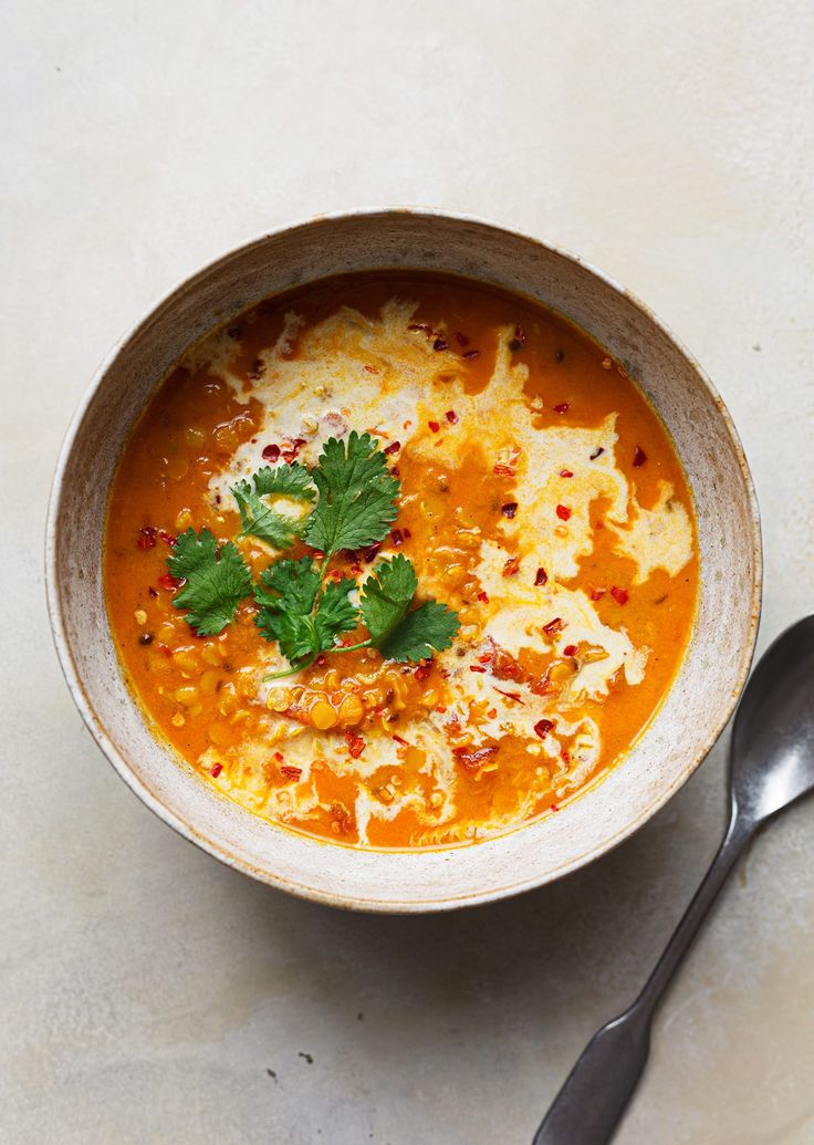 a white bowl filled with soup and garnished with parsley