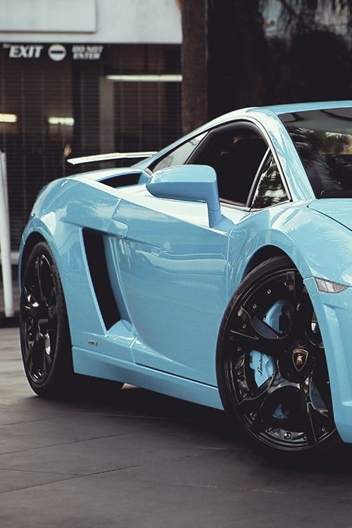 a blue sports car parked in front of a building