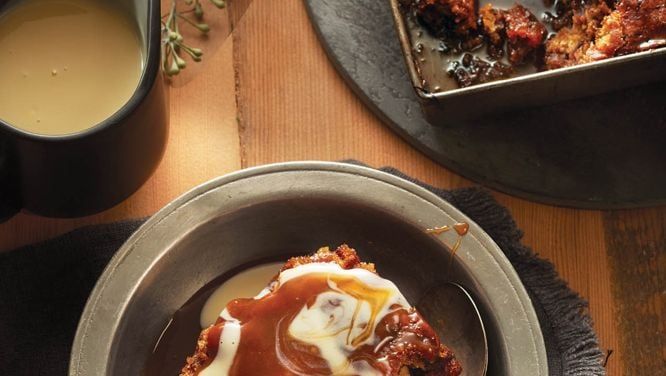 a bowl filled with food next to a cup of coffee on top of a wooden table