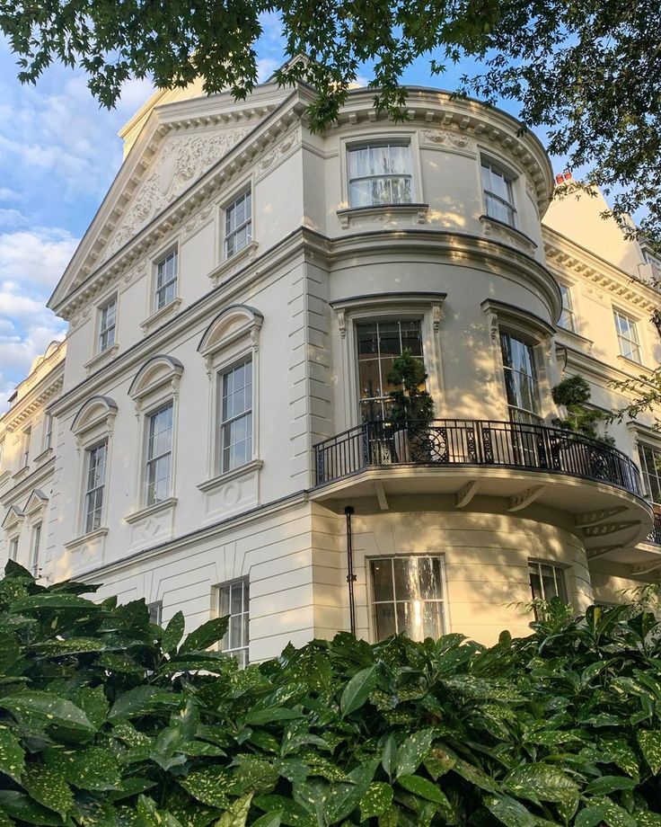 a large white building with balconies on the second floor and balcony above it