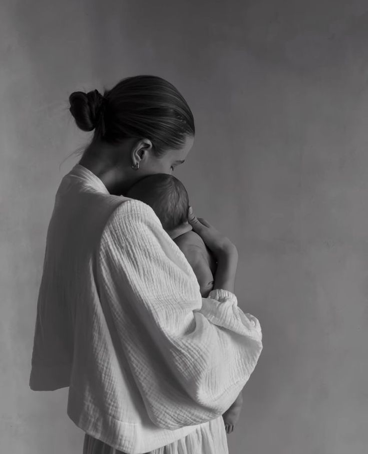 a black and white photo of a woman with her back to the camera, wearing a robe