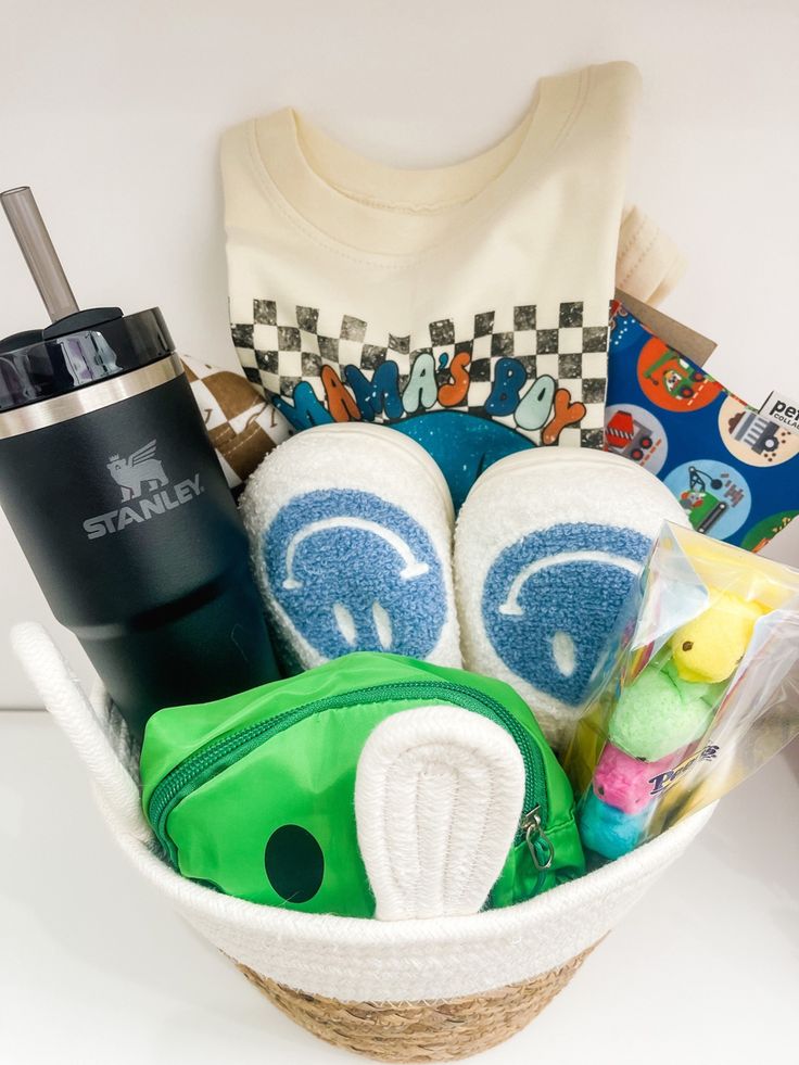 a basket filled with toys and items on top of a white table next to a t - shirt