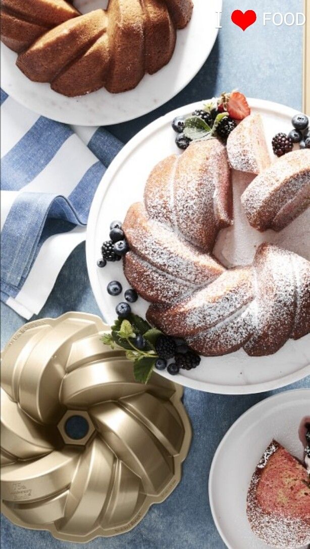 a table topped with cakes and bundt cakes covered in powdered sugar on top of plates