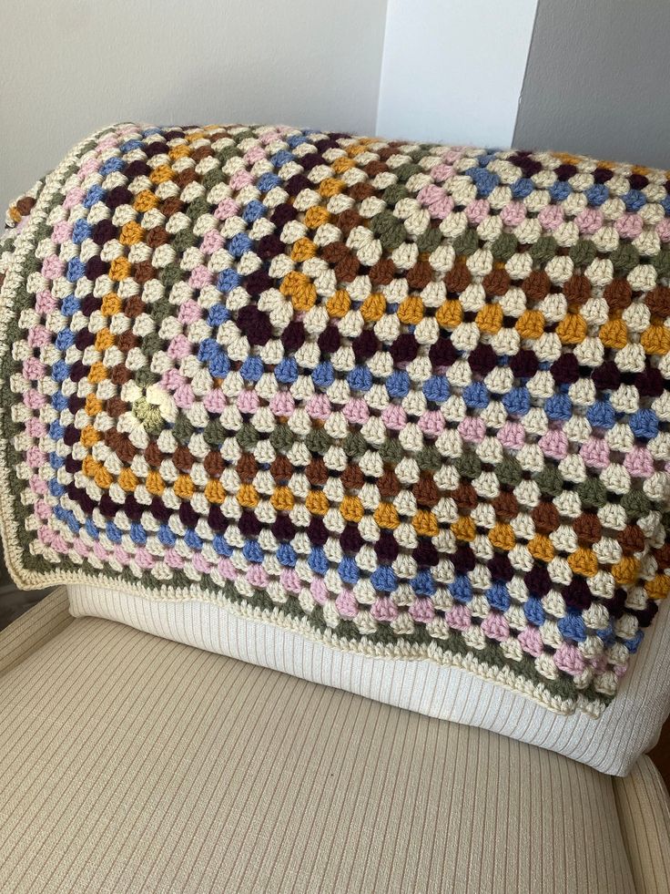 a crocheted blanket sitting on top of a chair