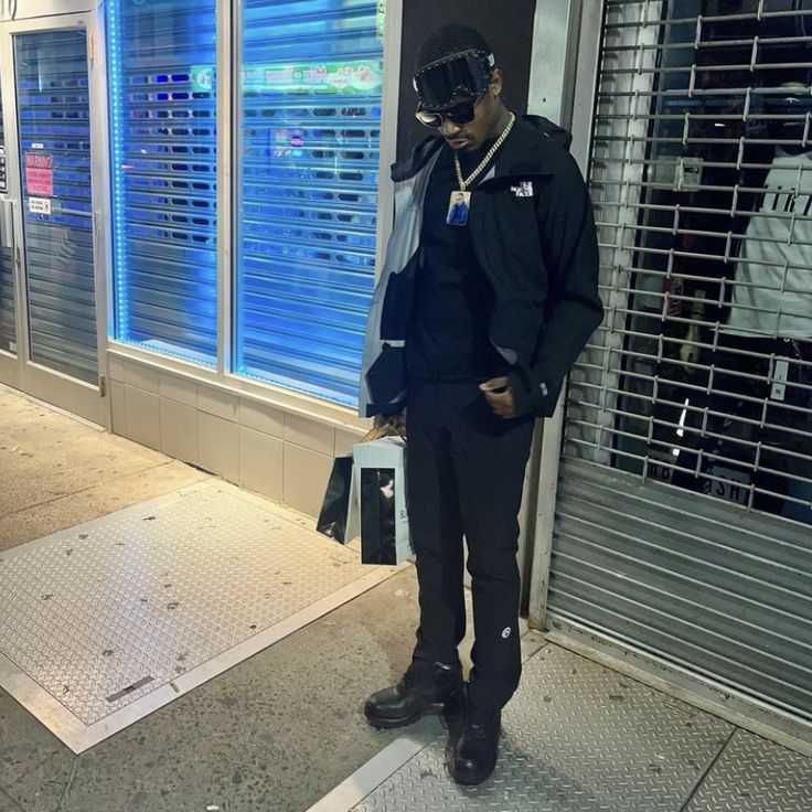 a man standing in front of a store window with his hand on his head and wearing a mask