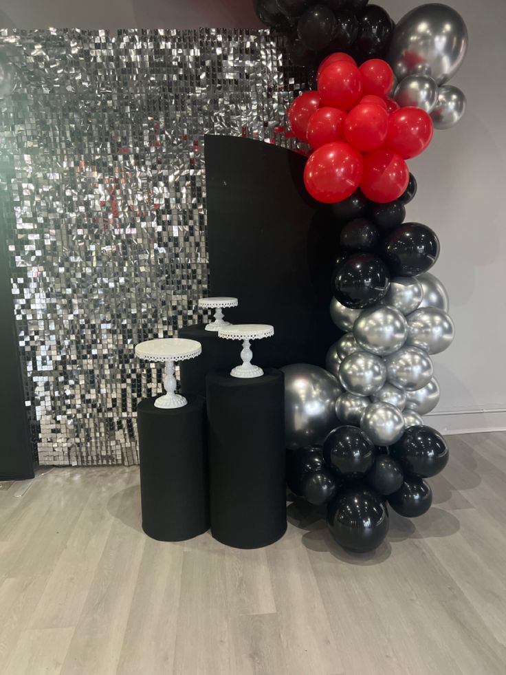 black and silver balloons are on display in the room