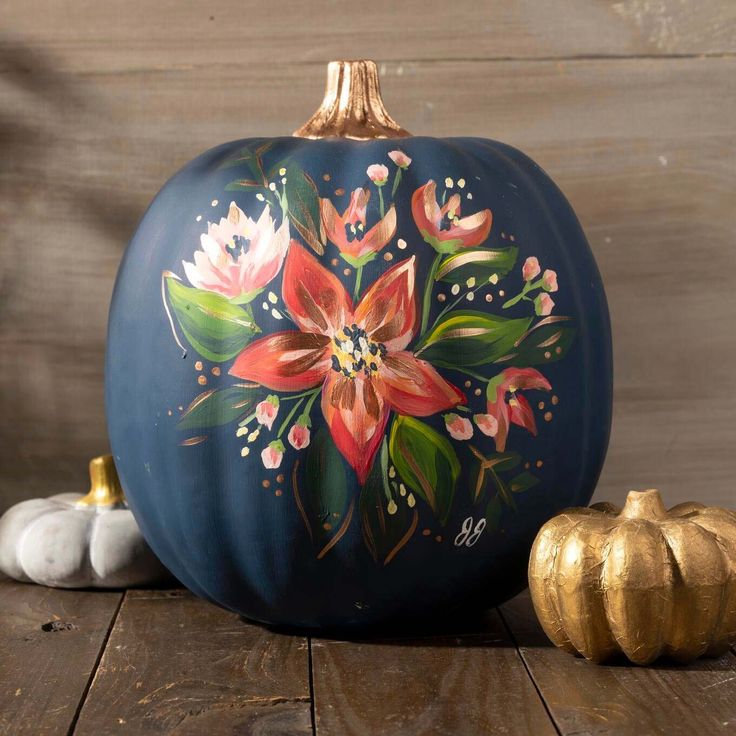 a painted pumpkin sitting on top of a wooden table