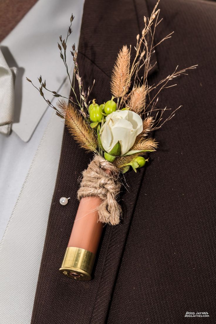 a boutonniere with white flowers and greenery is tied to a man's suit