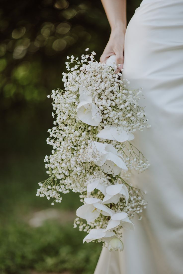 a bride holding a bouquet of white flowers