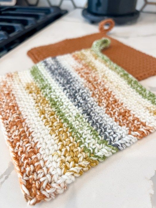 a crocheted dishcloth is sitting on a counter next to a stove top