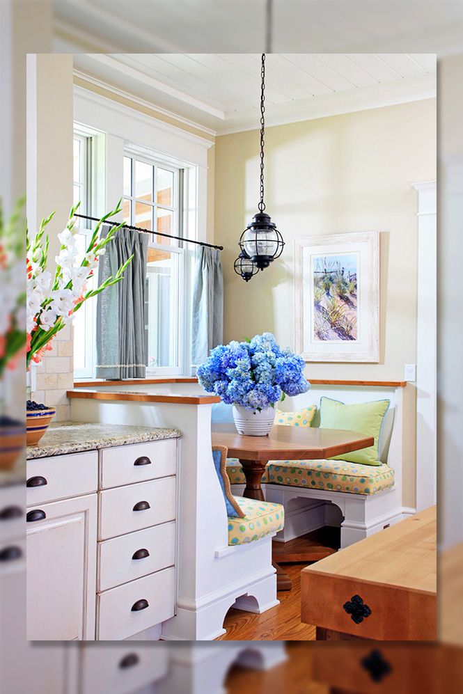 a kitchen with white cabinets and blue flowers in a vase on the counter next to an island