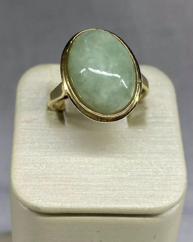 VINTAGE Jade 14k Solid Hold Oval Cabochon Ring  This beautiful ring features a stunning oval-shaped natural jade stone set in a 14k yellow gold bezel setting. The stone measures 14mm in length and 10mm in width, with a tapering band width of 2.5mm to 1.5mm. The ring weighs 2.88 grams or 1.85 dwt.    The authentic jade stone is the centerpiece of the ring, with no additional gemstones. Oval Jade Rings In Yellow Gold, Vintage Oval Jade Emerald Ring, Vintage Oval Jade Rings, Vintage Oval Emerald Ring In 14k Gold, Vintage 14k Gold Oval Cabochon Emerald Ring, Vintage 14k Gold Emerald Oval Cabochon Ring, Antique Oval Emerald Ring Stamped 14k, Classic Oval Emerald Collectible Ring, Classic Oval Emerald Ring Collector's Item