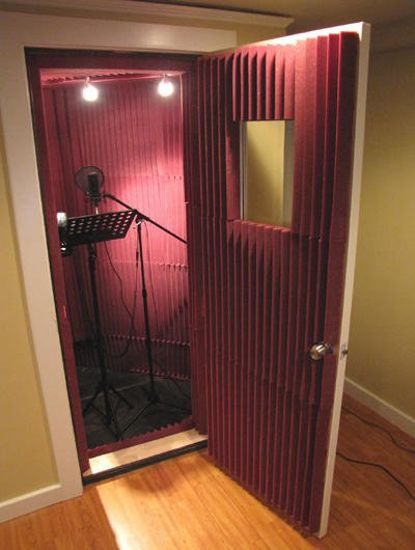 an empty room with a microphone in the corner and lights on either side of the door