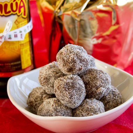 a bowl filled with powdered sugar covered donuts next to a bag of nutella