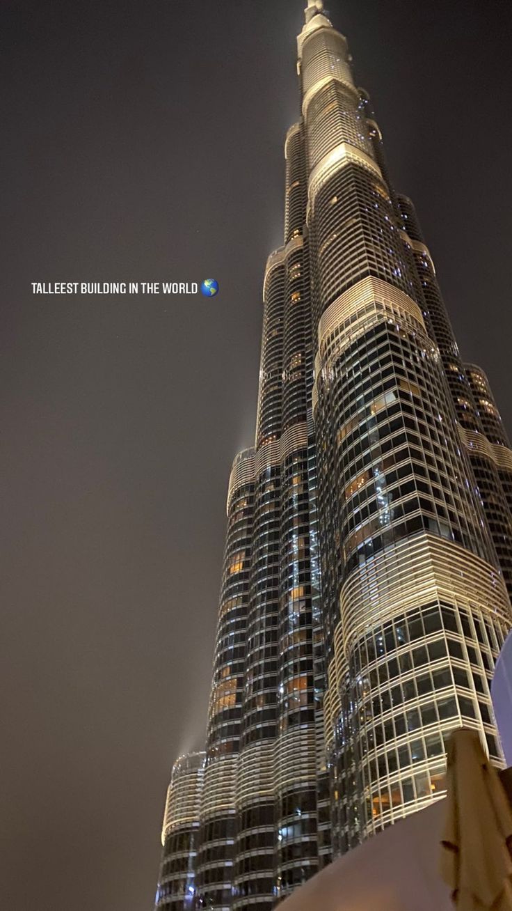 the tallest building in the world is lit up at night with an interesting message on it