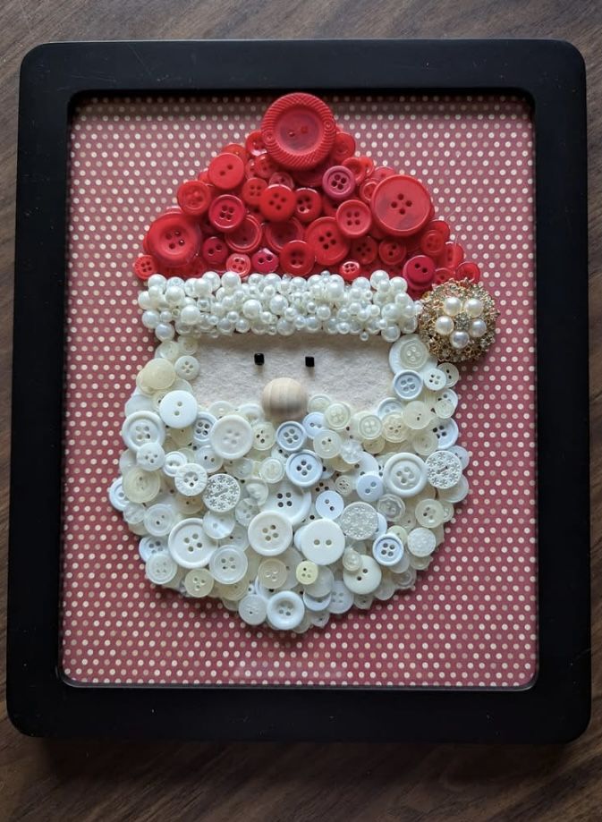 a santa clause made out of buttons in a frame