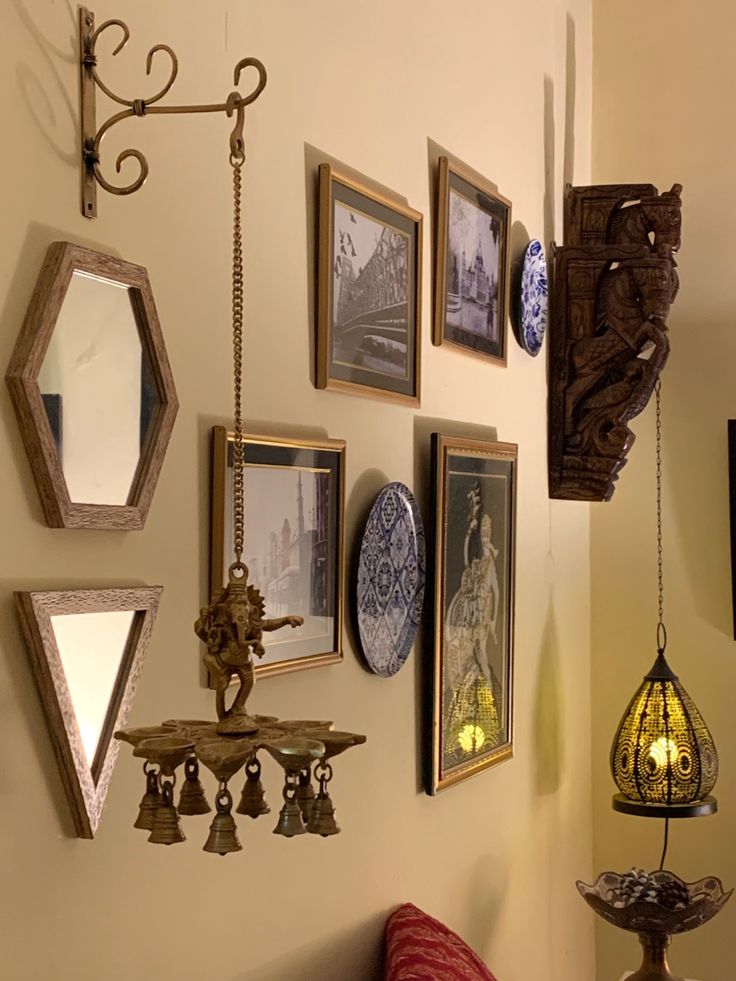 there are many pictures on the wall with lights hanging from it's hooks and lamps