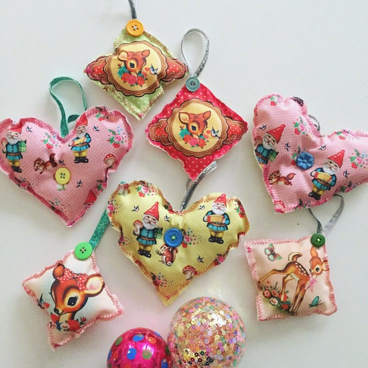 several decorative heart shaped ornaments are arranged on a white surface, including one with an ornament in the shape of a cat