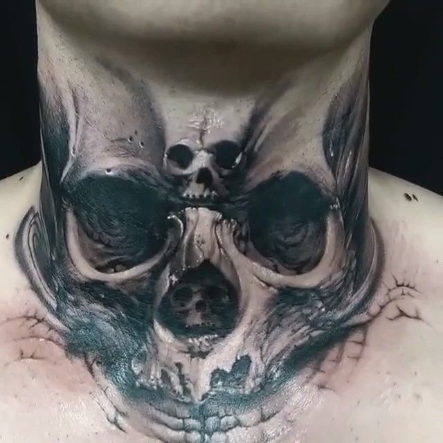 a man's neck is covered in skulls and bones, while his face has been painted black