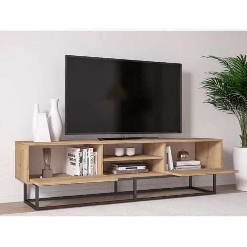 a flat screen tv sitting on top of a wooden entertainment center next to a potted plant