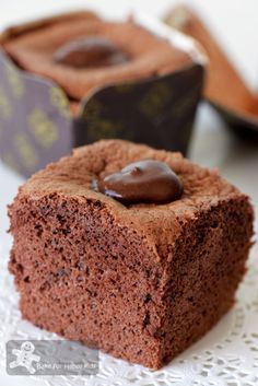 a piece of chocolate cake sitting on top of a white doily